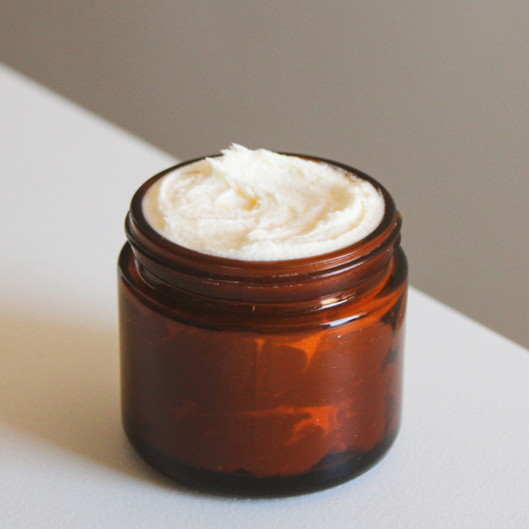 A jar of Lunar Rest whipped tallow face moisturizer with a creamy white product visible at the top