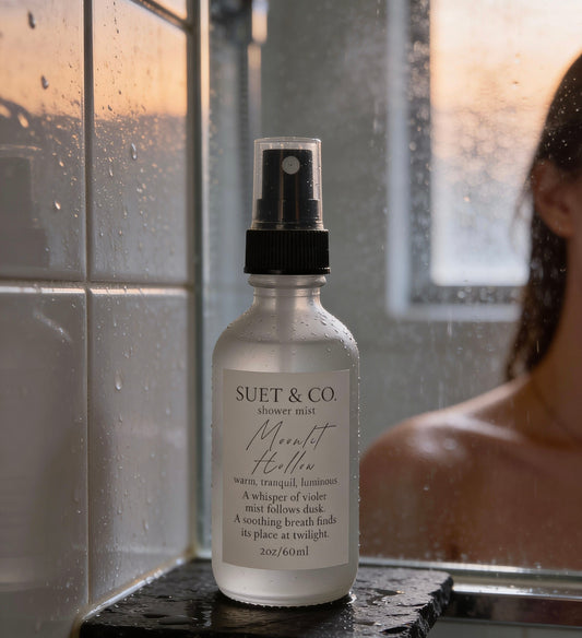 Bottle of Suet & Co. Moonlit Hollow aromatic shower mist product on a shelf in a shower setting